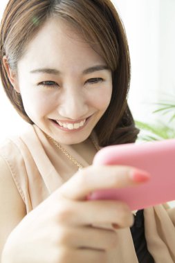 Akıllı telefon kullanan güzel Asyalı kadın, portreyi kapat.