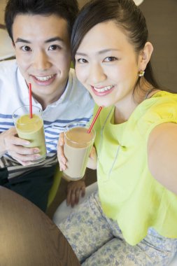 Kahve molasında tablete aşık Asyalı çift 