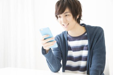 Japon adam beyaz arka planda cep telefonu kullanıyor