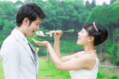 Asyalı düğün çifti, gelin damadı pastayla besliyor