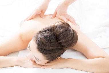 Sırt masajından hoşlanan genç Japon kadın. güzellik ve kaplıca konsepti.