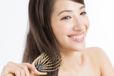 Güzel Japon kadın saçını tarıyor beyaz arka planda.