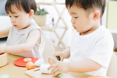 Evde oyuncaklarla oynayan sevimli Japon çocukları.