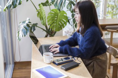 Kafede dizüstü bilgisayar kullanan güzel genç kadın