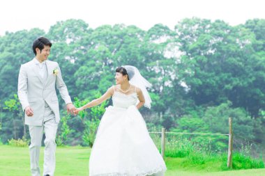 Parkta poz veren Asyalı gelin ve damat 