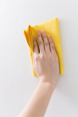 Beyaz arka planda sarı paçavralar olan kadın eli