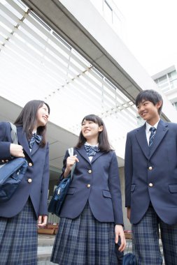 Çantalı gülümseyen Japon öğrencilerin portresi. 