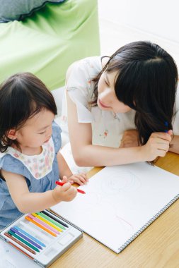 Annesiyle resim çizen tatlı Asyalı kız.