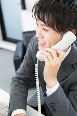 young asian businessman using  phone  in office