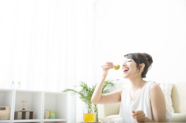 Sabahları kek yiyen ve taze meyve suyu içen bir kadın.