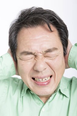 Baş ağrısı olan yaşlı bir Asyalı.