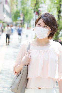 Koruyucu maskeli genç bir Japon kadının portresi.