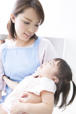 Genç Asyalı anne ve küçük ağlayan bebeği 