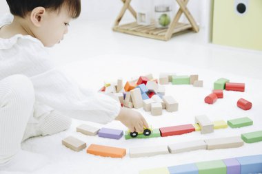 Evde oyuncaklarla oynayan sevimli Asyalı kız.