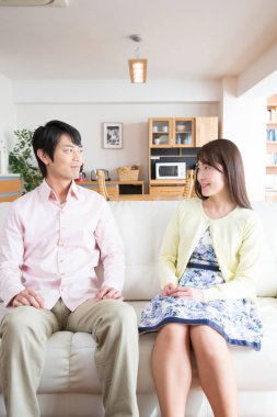 Oturma odasındaki kanepede oturan genç çift.