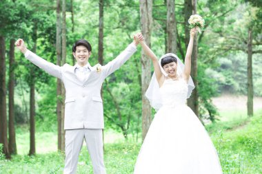 Parkta poz veren Asyalı gelin ve damat 