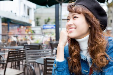 Kafede oturan şapkalı genç kadın. 