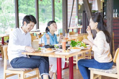 Asyalı arkadaşlar restoranda yemek yiyorlar. 