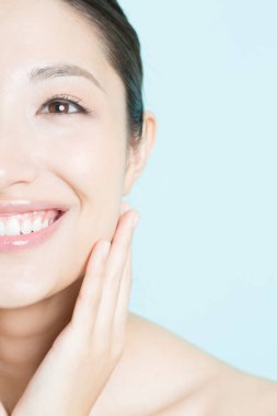Güzel, genç Asyalı bir kadın. Temiz ciltli gülümsüyor. yüz tedavisi, kozmetoloji, spa ve sağlık