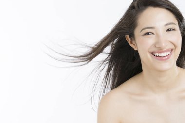 Uçan rüzgâr saçlı mutlu genç kadın beyaz arka planda izole edilmiş.