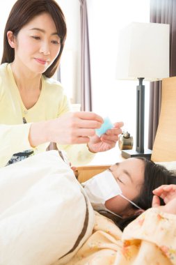 Asyalı kadın çocuğuna bakıyor. 