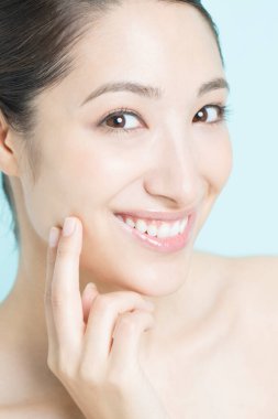 Güzel, genç Asyalı bir kadın. Temiz ciltli gülümsüyor. yüz tedavisi, kozmetoloji, spa ve sağlık