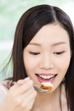 Restoranda yemek yiyen Asyalı kadın. 