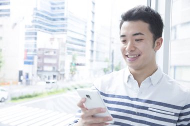 Akıllı telefonlu genç Asyalı adam.