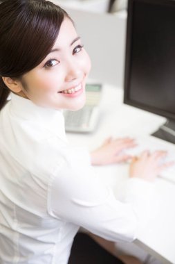 Genç Asyalı kadın işte gülümsüyor.