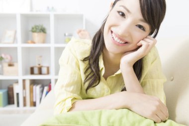 Asyalı kadın evde dinleniyor.