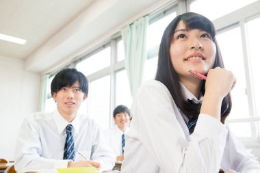 Genç Japon öğrenciler sınıfta okuyor.