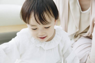 Küçük Asyalı kız annesiyle oynuyor.