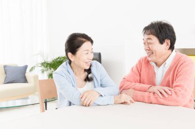 Evde dinlenen yaşlı çiftin portresi.