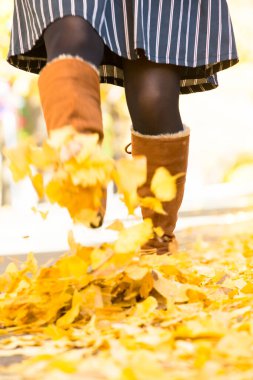 Sarı akçaağaç yapraklı kız sonbahar parkında.