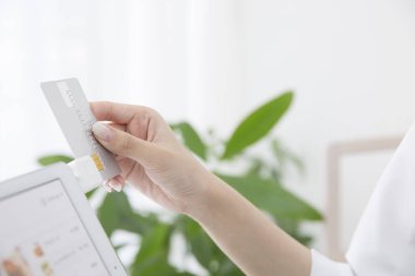 Ödeme Makinesinin ya da POS Terminalinin yanındaki kredi kartını tutan kadını kapat 