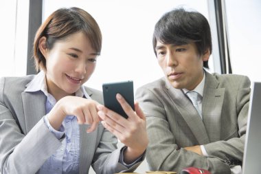 İşletme ekibi akıllı telefonuyla ofiste çalışıyor. 