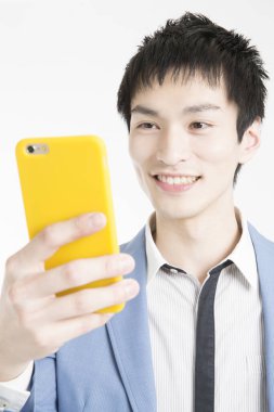 Beyaz arka planda akıllı telefon tutan genç adamın portresi