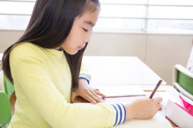 Şirin Asyalı kız sınıfta okuyor.