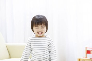 Asyalı kız evde gülümsüyor. 