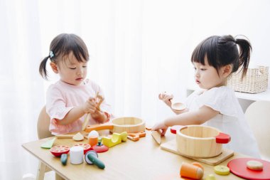 Ev içi oyuncaklarla oynayan sevimli Japon kızlarının yakın çekimleri. 