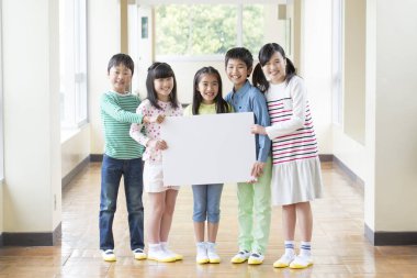 Boş tahtası olan mutlu okul çocuklarının portresi. 