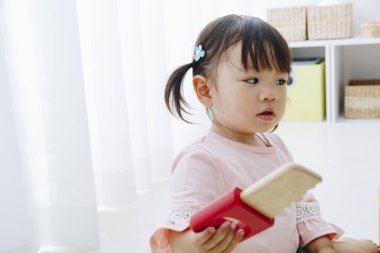 Ev içi oyuncaklarla oynayan sevimli Japon kızın yakın çekimi. 