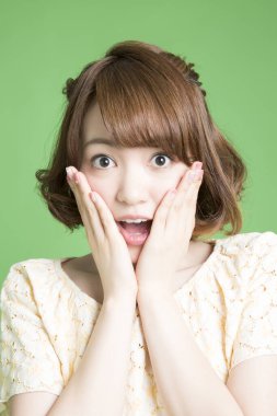 Güzel Japon kadının portresi yeşil arka planda şaşırdı. 