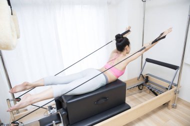 Spor giyinen Japon kadın iç mekanda antrenman yapıyor.