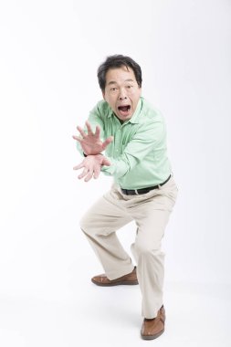 Asyalı adam beyaz arka planda elleri olan canavar çene gösteriyor.