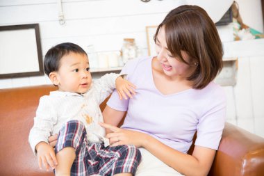 Mutlu Asyalı anne ve oğul evde oynuyorlar.