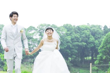 Parkta poz veren Asyalı gelin ve damat 