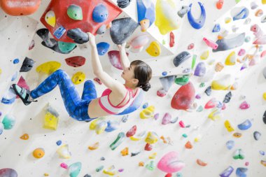 Sportif Asyalı kadın kaya duvarına tırmanıyor