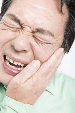 Diş ağrısı olan Asyalı bir adamın portresi. 