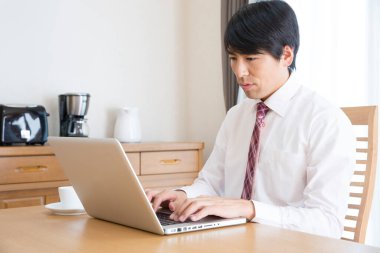 Ofisinde dizüstü bilgisayarda çalışan bir adam.